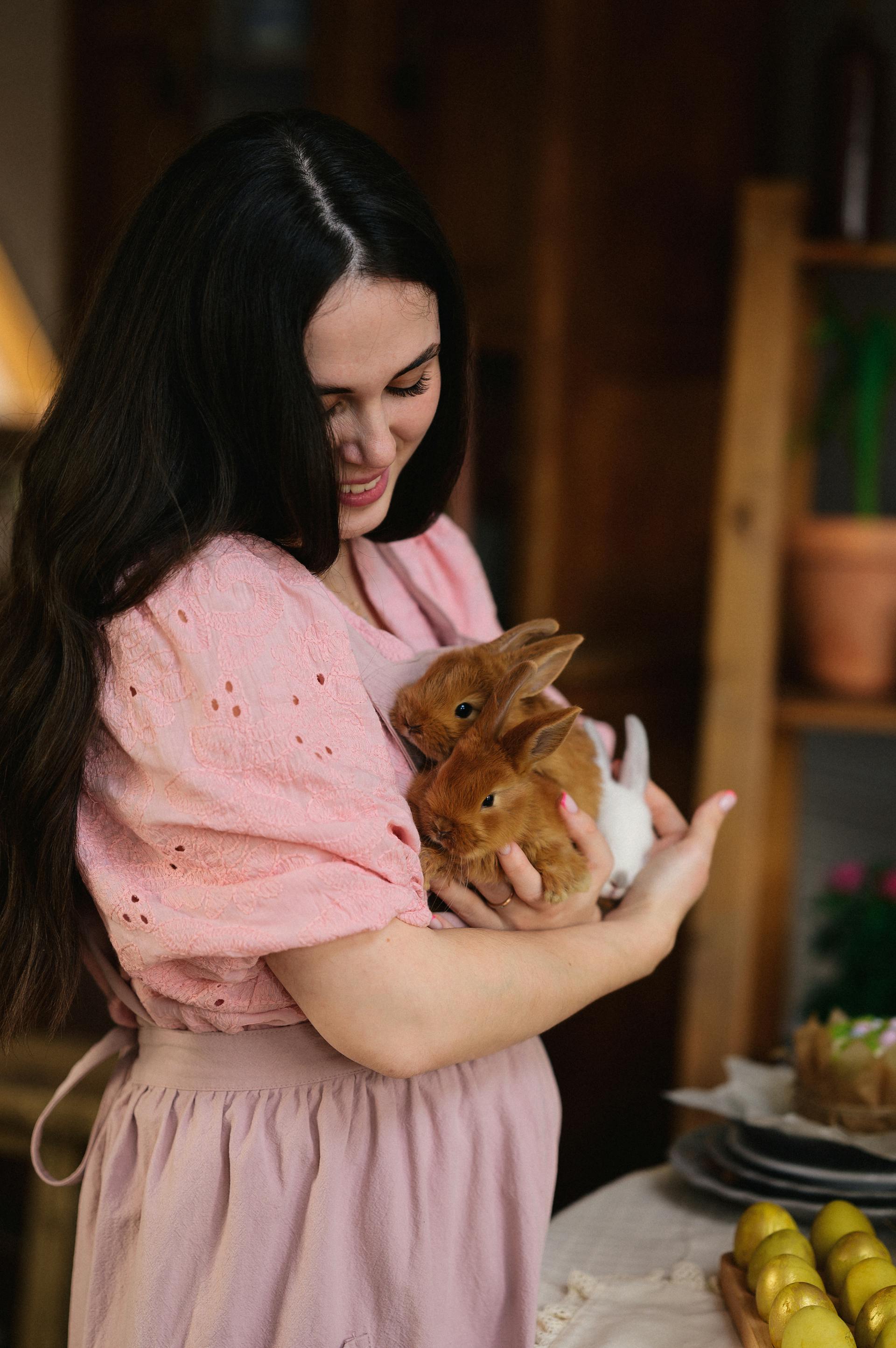 A smiling woman holding rabbits | Source: Pexels