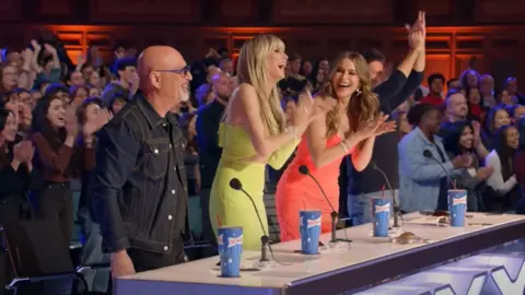 Simon and the other judges reacting to John's performance on America's Got Talent