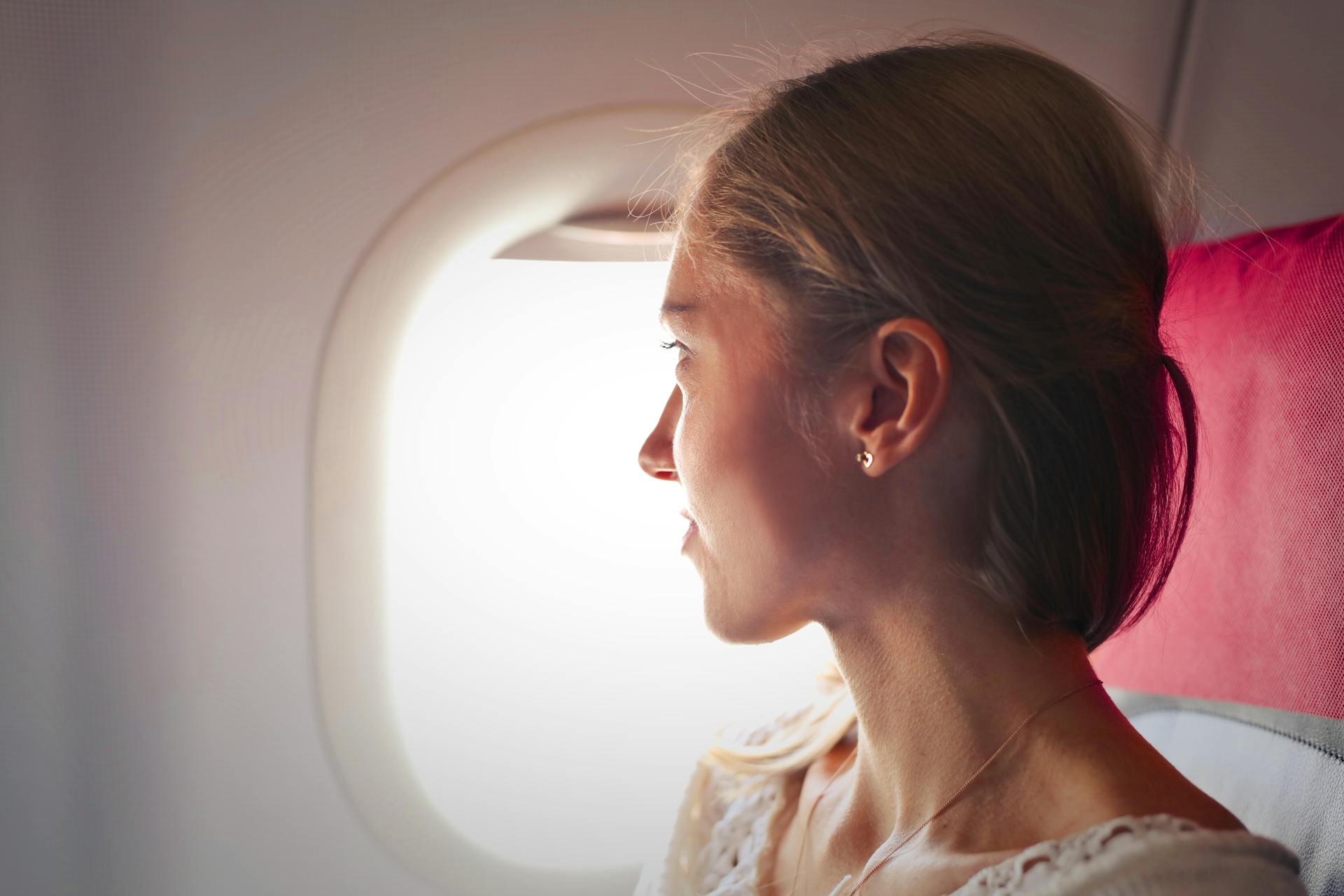 A woman looking outside an airplane window