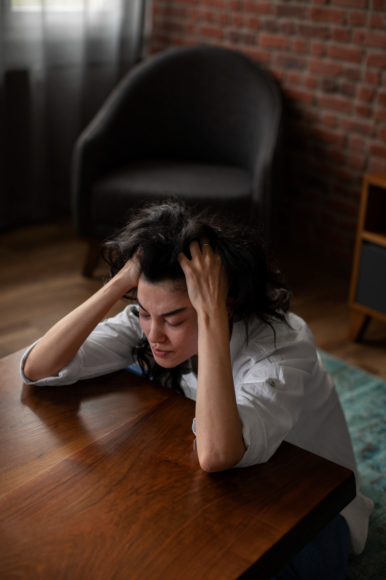 A frustrated woman sitting by a table | Source: Freepik