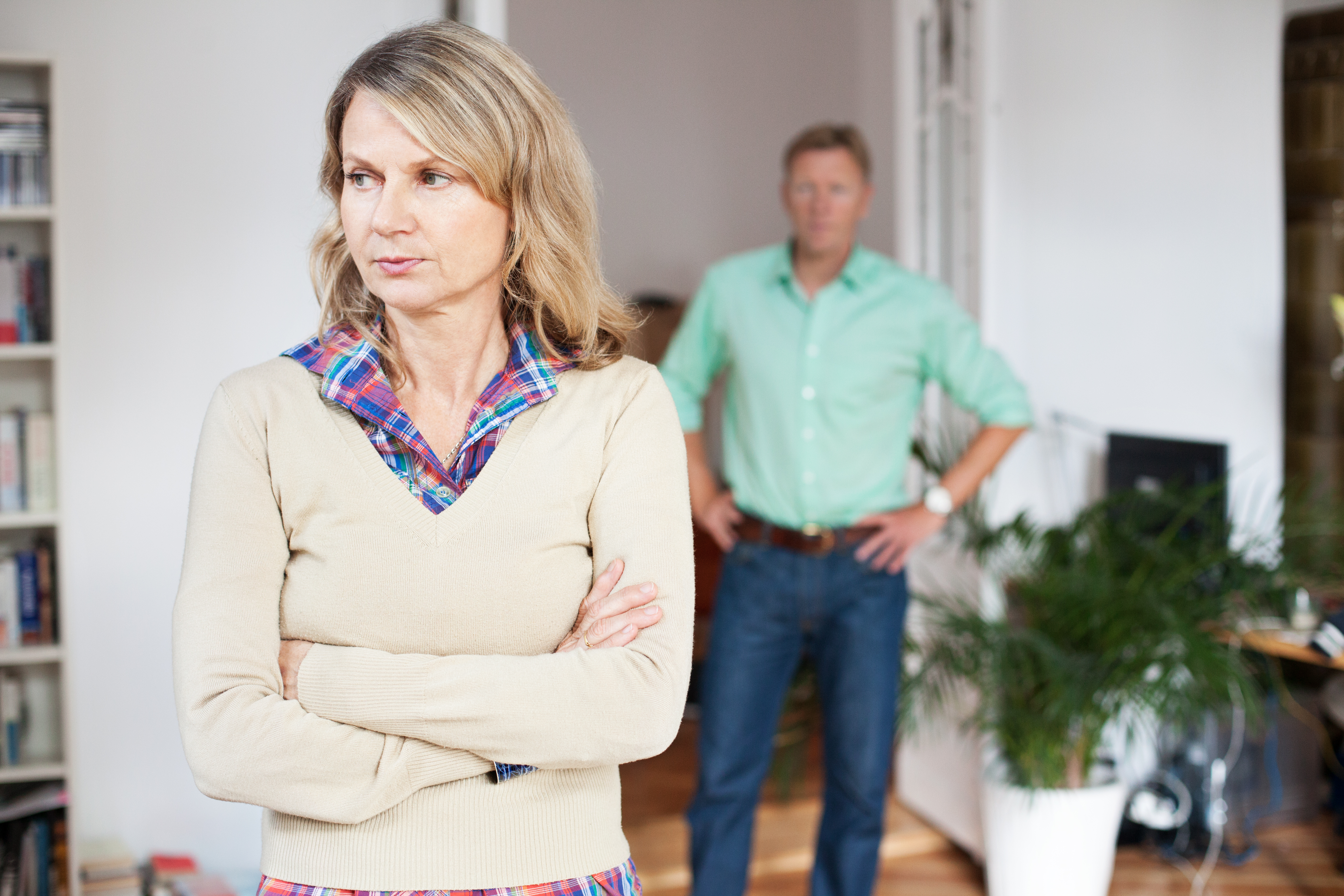 An upset man standing behind a woman | Source: Getty Images