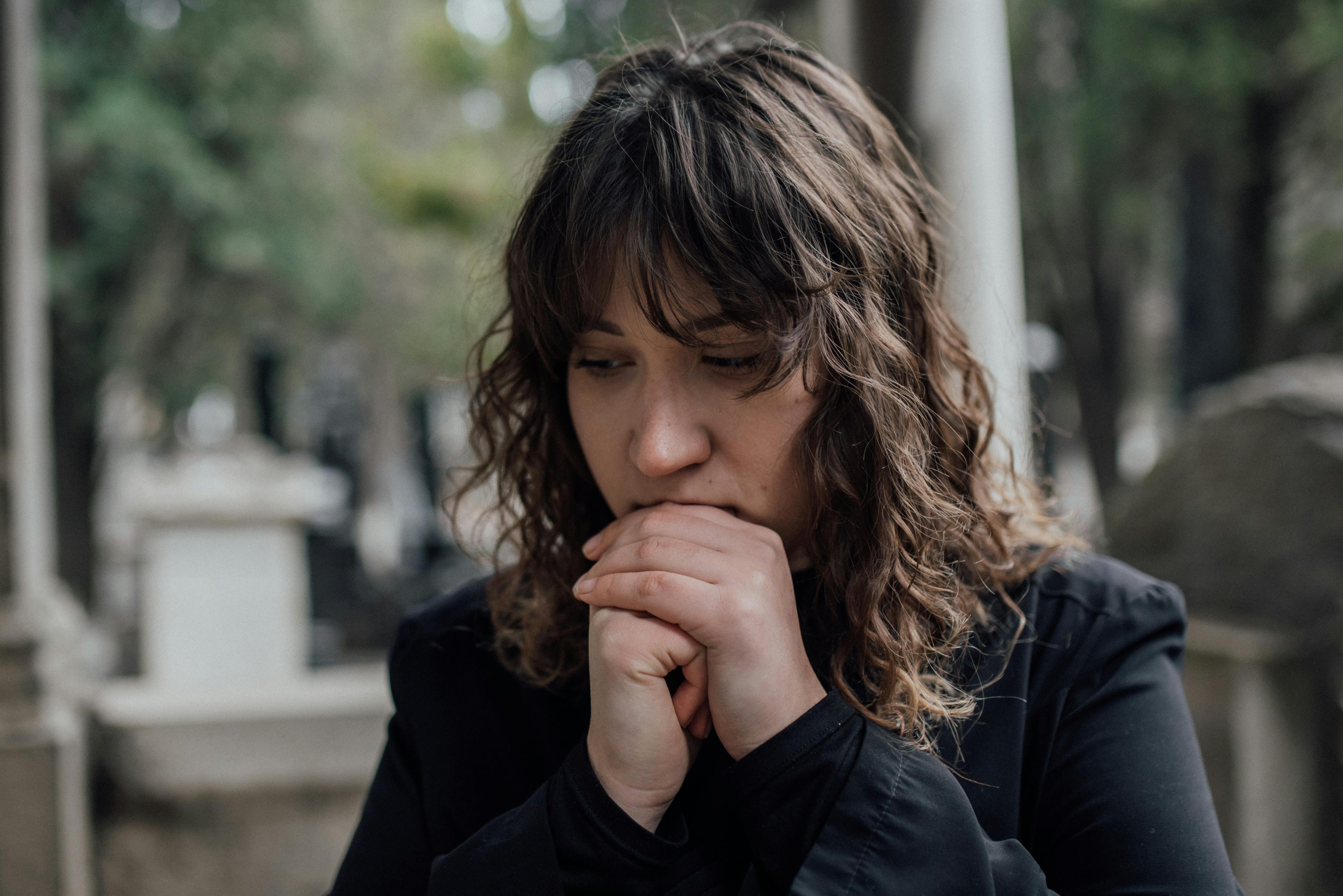 A silent woman looking at a headstone | Source: Pexels