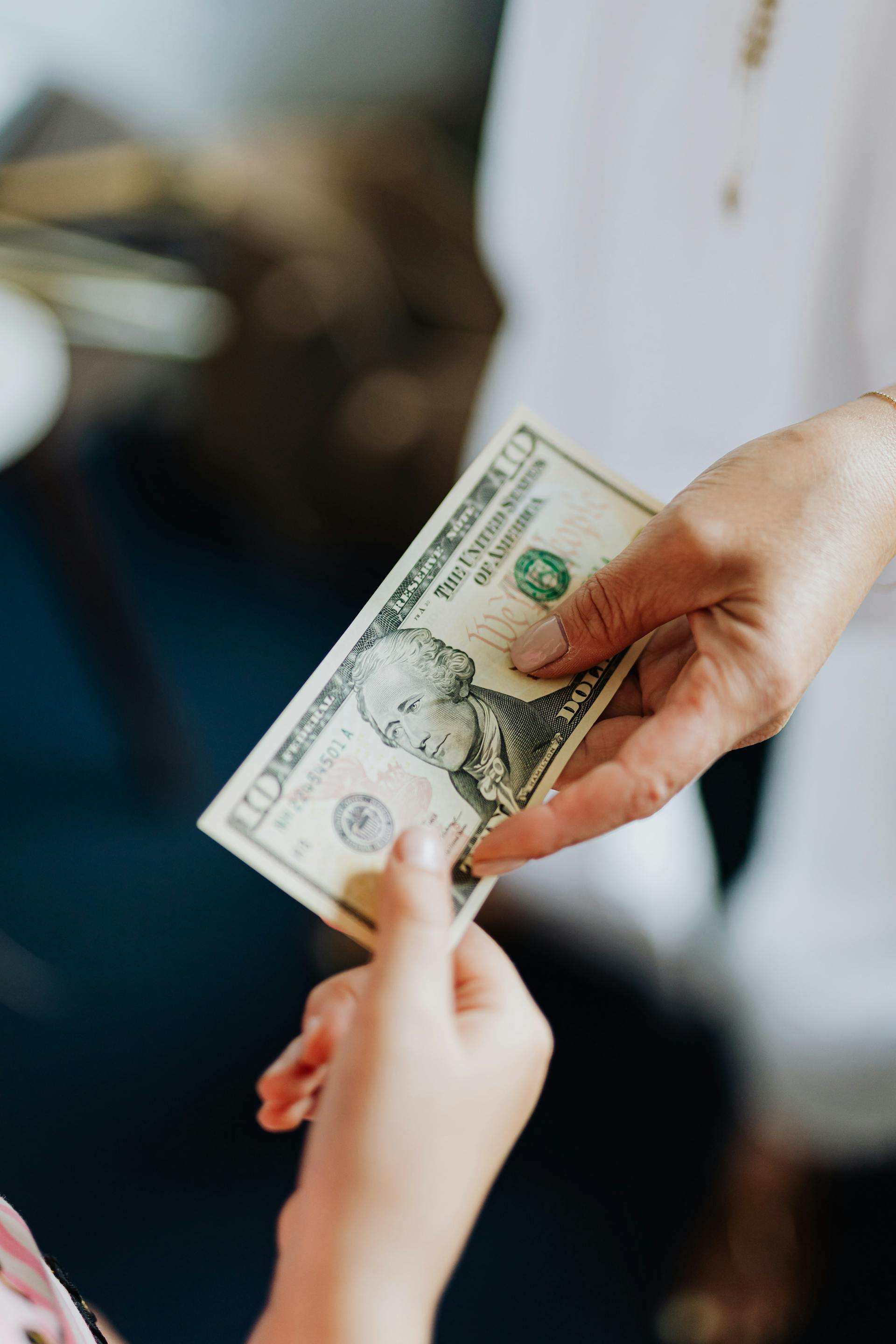 Close-up of a woman giving $10 to a kid | Source: Pexels