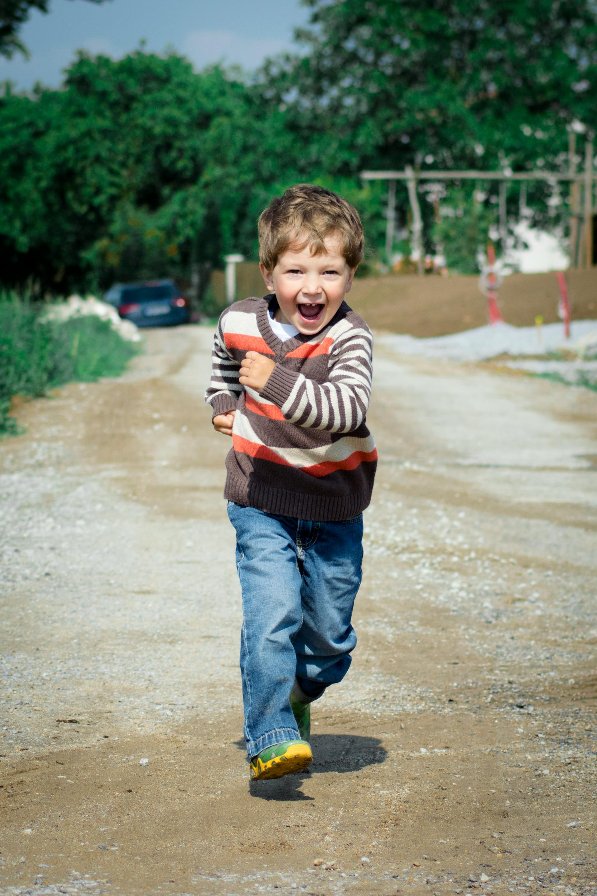 A happy little boy running on the road | Source: Pexels