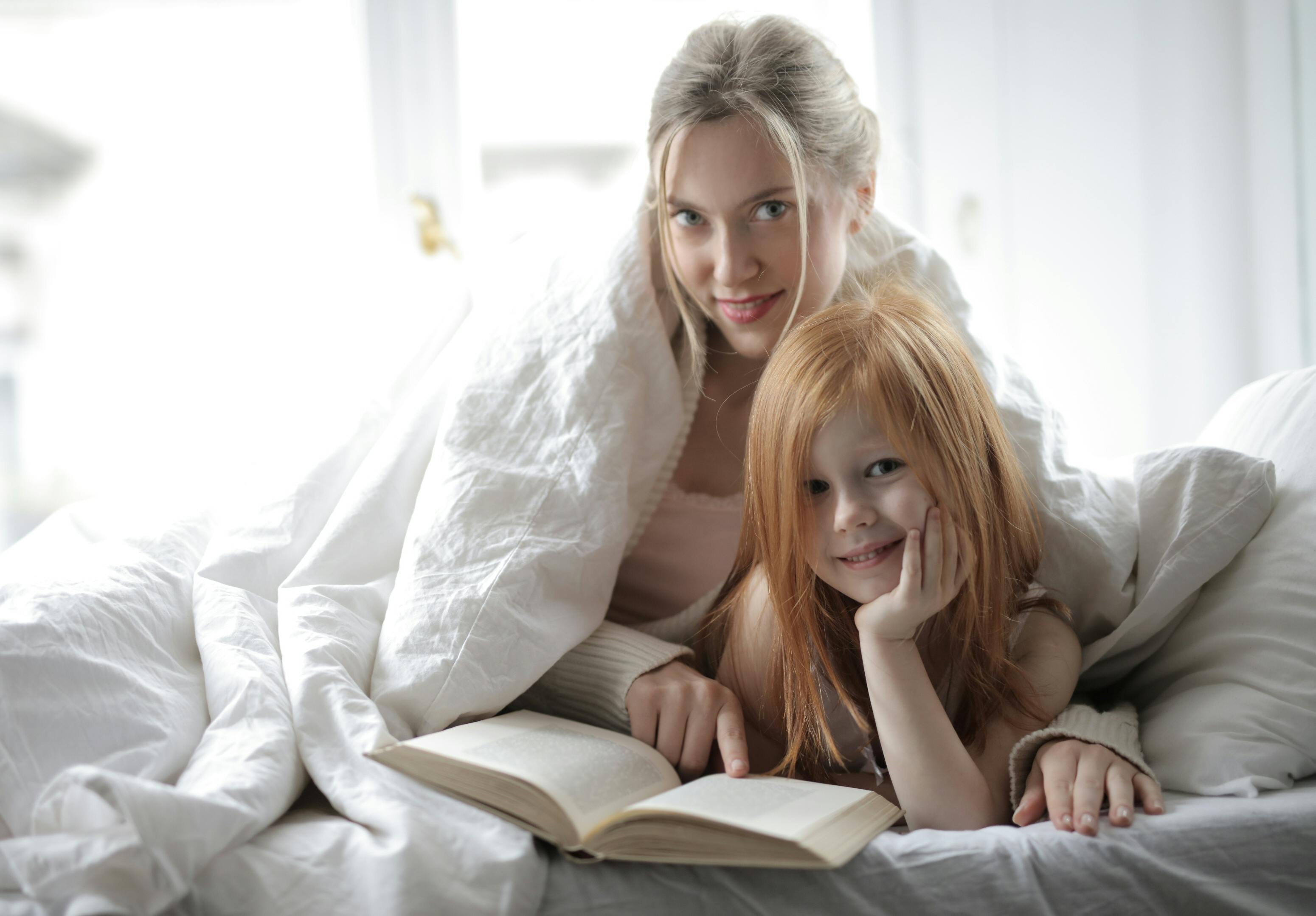 A mother and her daughter reading a book together