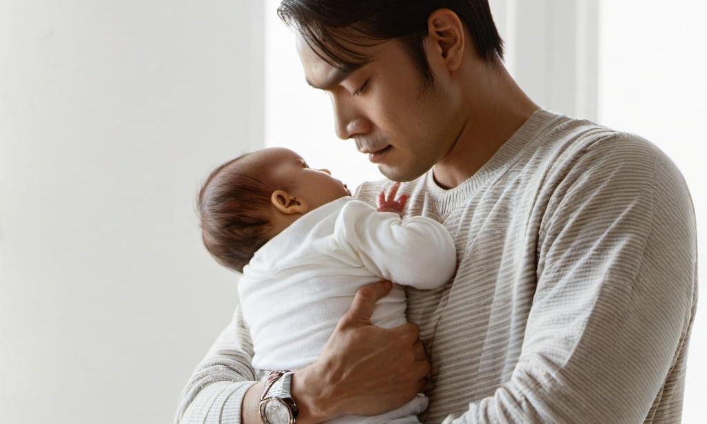 A father looking weary while holding his child | Source: Midjourney